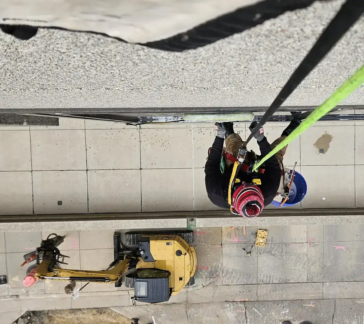 Rope access technician cleaning high-rise glass